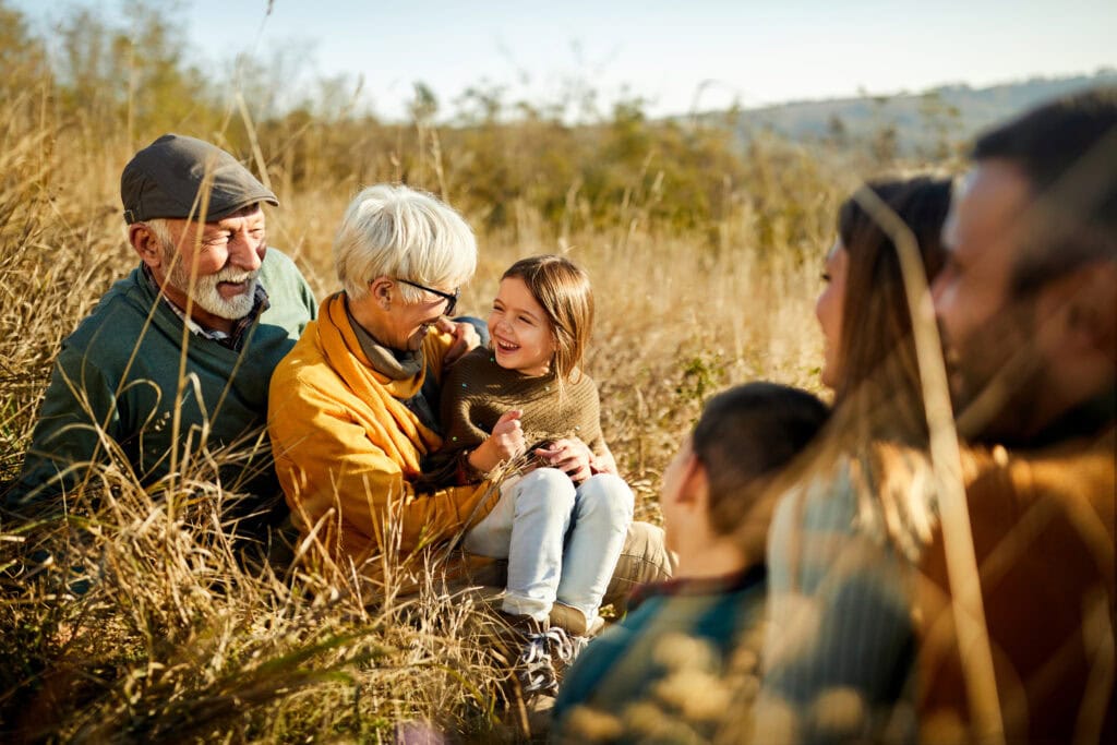Gezinnen genieten van een leuke dag in de natuur bij de Vliegbasis, met zonnig weer en gouden grasvelden, perfect voor familie-uitjes en outdoor activiteiten.