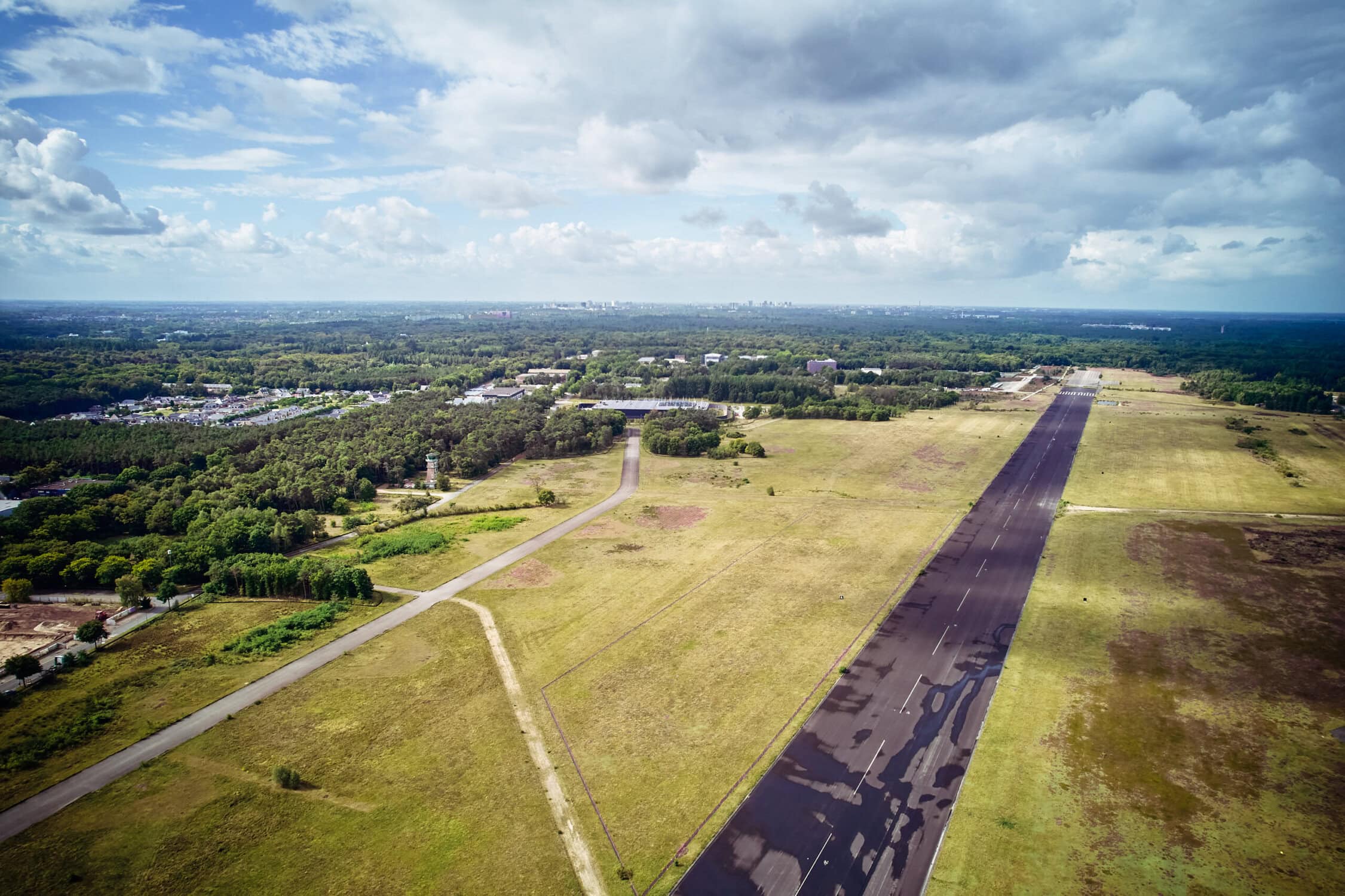 Vliegbasis in Nederland met start- en landingsbaan en groen omliggend landschap, klaar voor militaire en civiele vluchten.