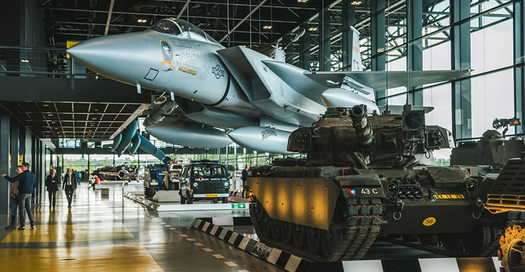 F16 gevechtsvliegtuig en tanks op de Vliegbasis W210, showcasing militaire luchtvaart en landmacht voertuigen.