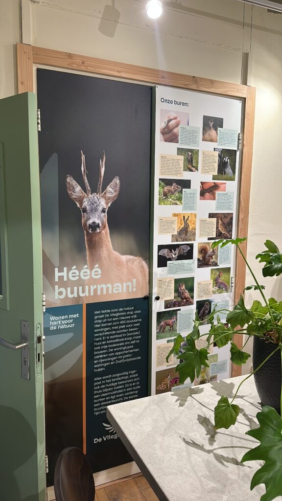 Natuurlijke wonen en duurzaamheid bij Vliegbasis: informatieve display over lokale flora en fauna, inclusief witte ree. Ideaal voor natuurliefhebbers en duurzame woninginrichting.