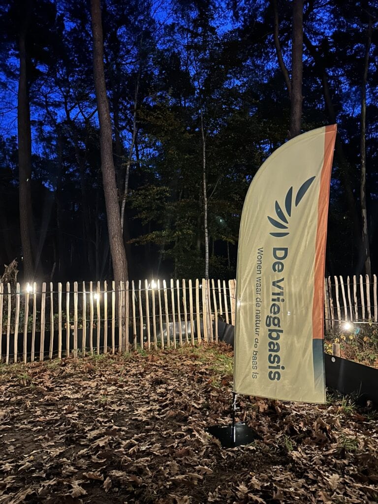 Gezicht op het bos bij de Vliegbasis met een promotieband en het natuurreservaat signaal, benadrukt de natuurlijke omgeving en de rust van de Vliegbasis in Nederland.