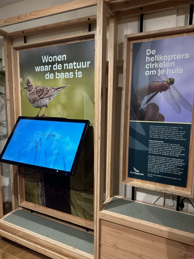 Vliegen in de natuur en de rol van de helikopters in de omgeving, educatieve displays over natuurbehoud en de biodiversiteit van De Vliegbasis, informatieve natuurbord en digitale schermen.