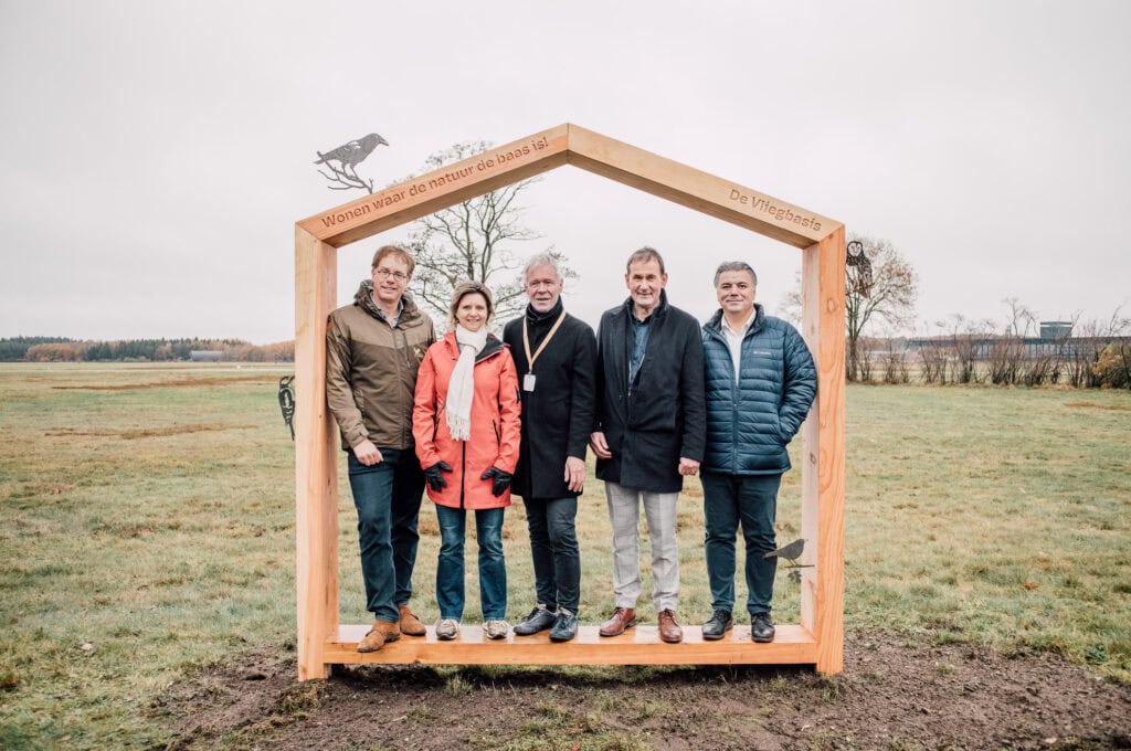 Unieke woonbeleving op de Vliegbasis: bewoners welkom in een natuurlijke omgeving met duurzame woningen en uitstraling die harmonie brengt tussen natuur en architectuur.