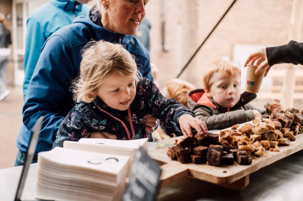 Gezellige kinderactiviteit op Vliegbasis, kinderen genieten van traktaties en samen ontdekken tijdens een familiedag.