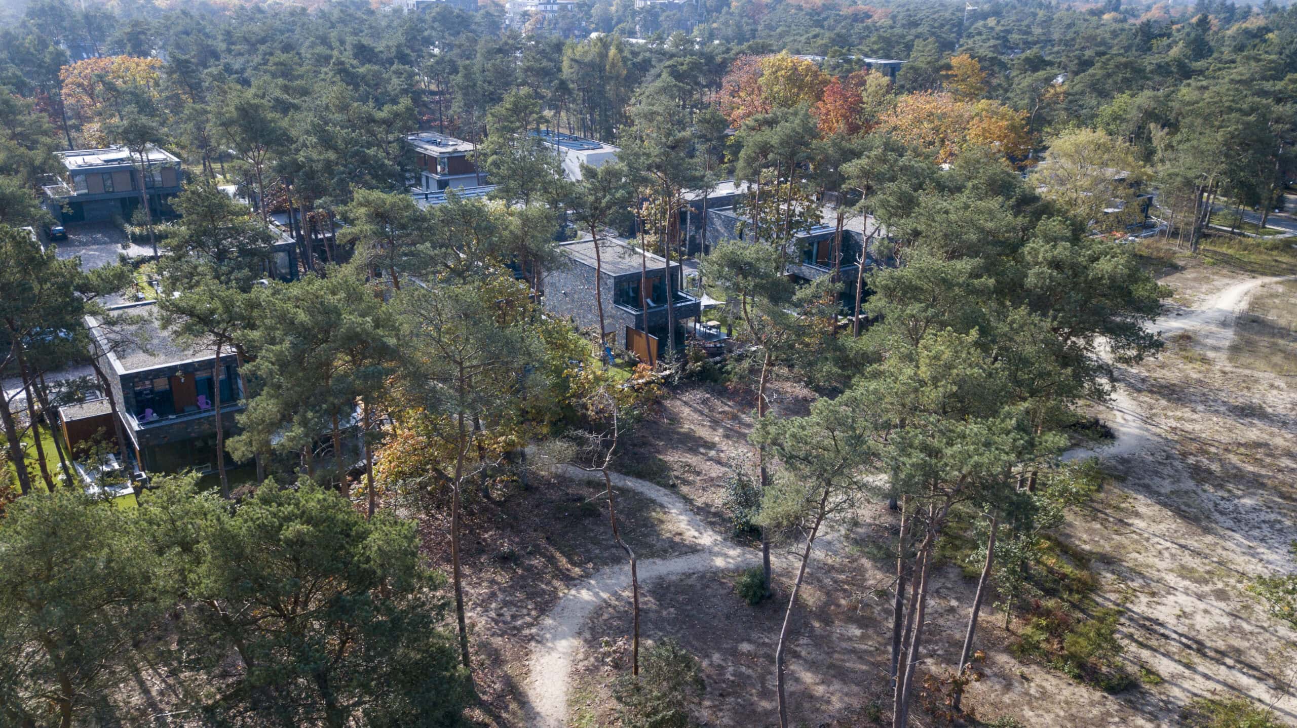 Moderne woning tussen bomen in een rustige, groene omgeving.
