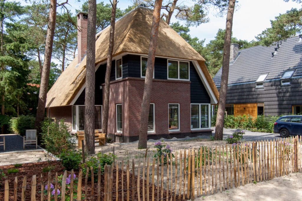Een charmant houten huis met rieten dak, gelegen in een bosrijke omgeving, klaar voor nieuwe bewoners. Perfect voor natuurliefhebbers die willen genieten van rust en privacy.