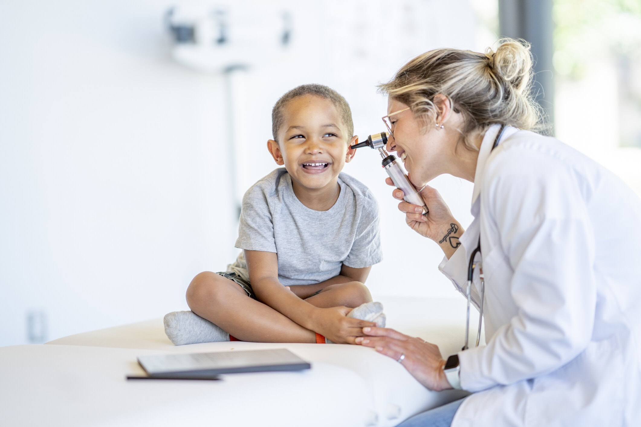 Kind krijgt medische controle van arts op Vliegbasis, lachend en ontspannen tijdens het onderzoek.